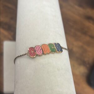 Coach Gold Bracelet with Colorful Letters and iPhone 15 case
